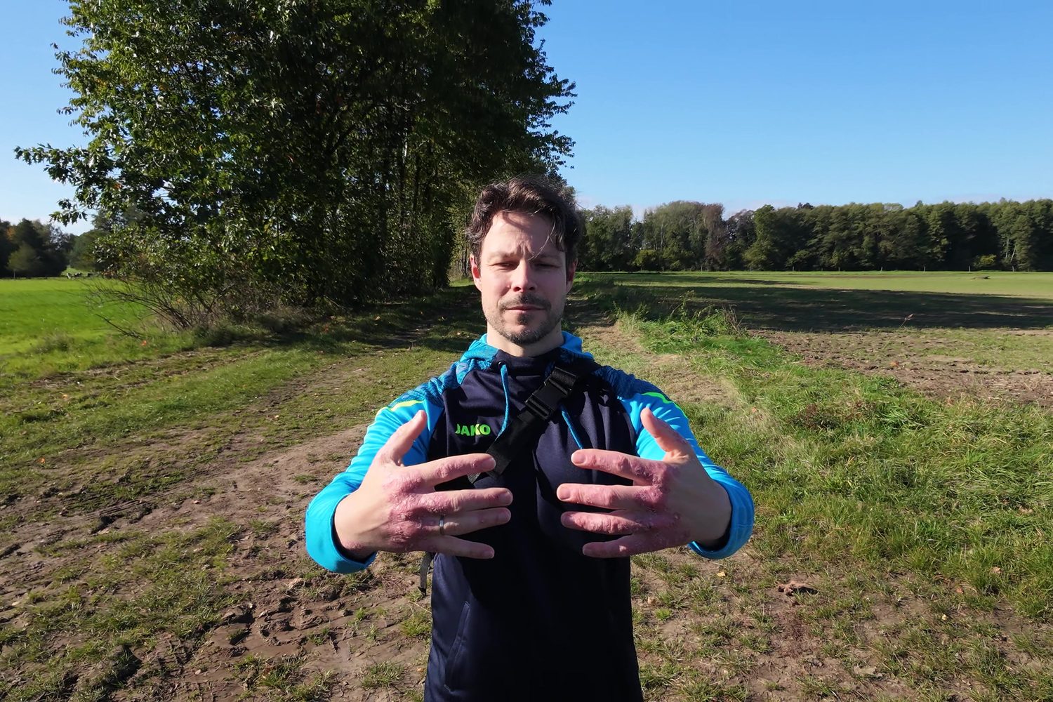 Dirk beim Qigong auf dem Feld, die Hände vor dem Körper